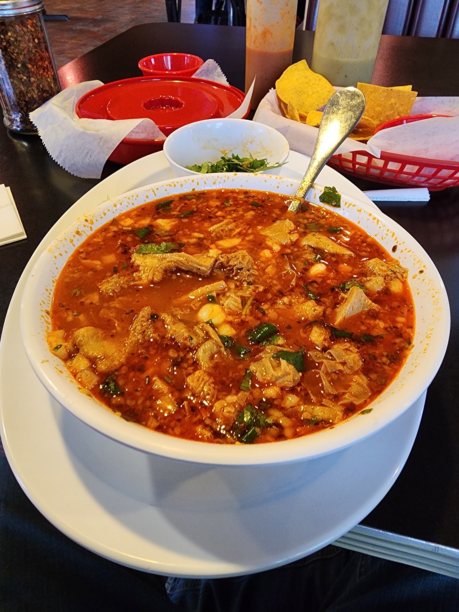 Large bowl of menudo with cilantro and hominy